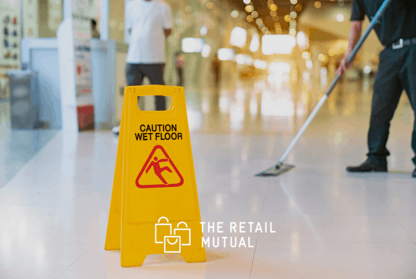 caution wet floor sign with person mopping in the background