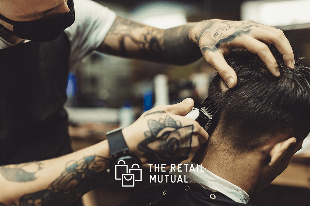 barber giving a cut wearing a face mask