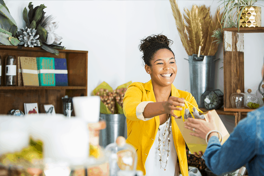 lady in yellow jacket smiling and serving a customer